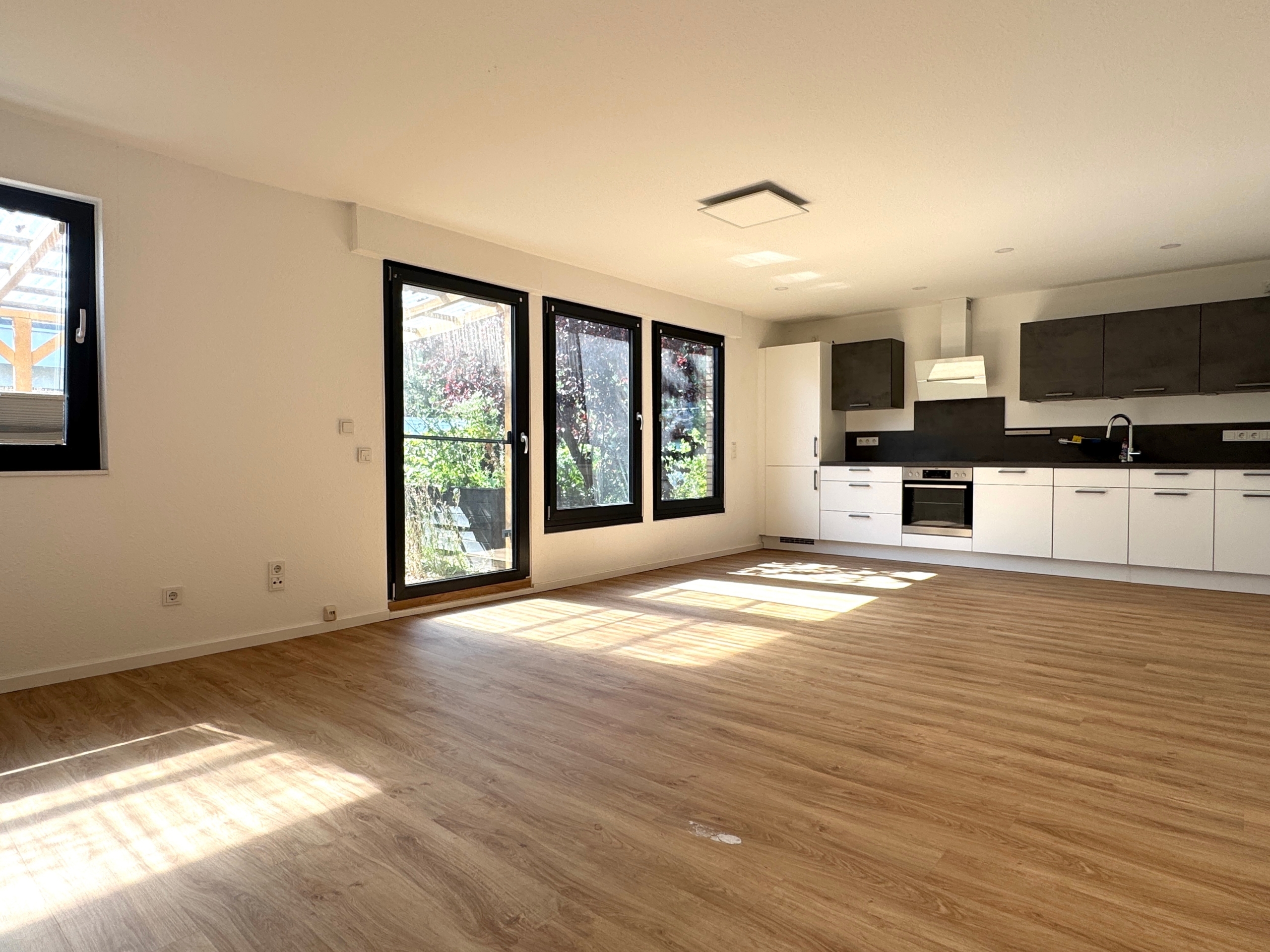 Wohnzimmer mit offener Küche und Zugang zur Terrasse